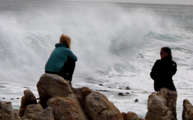 High waves at Stanfordsbaai yesterday. Visitors watching the whales while sitting at the far end of the rocks right in the way of the waves.